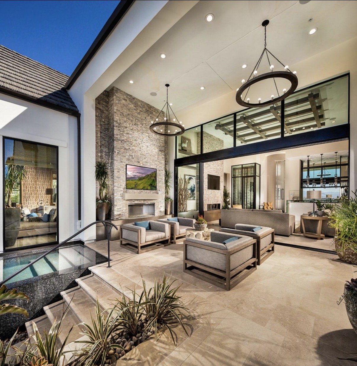 Covered outdoor lounge with ring chandeliers and spa